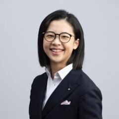 Charis Ma, smiling in a business suit with short dark hair.